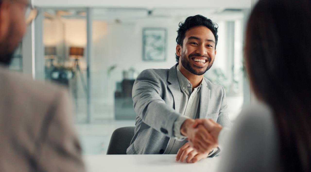 Attorney man smiling while talking to two business owners and shaking hands Attorney man smiling while talking to two business owners and shaking hands
