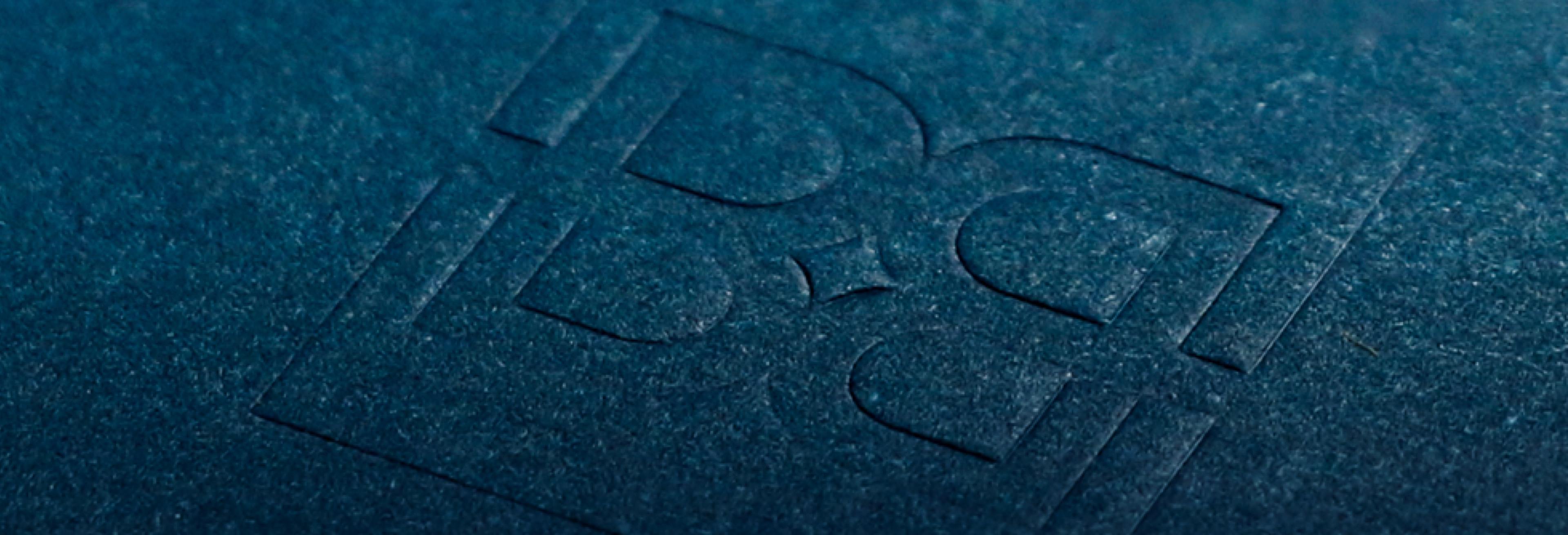 Burt Blee logo embossed on textured blue background.